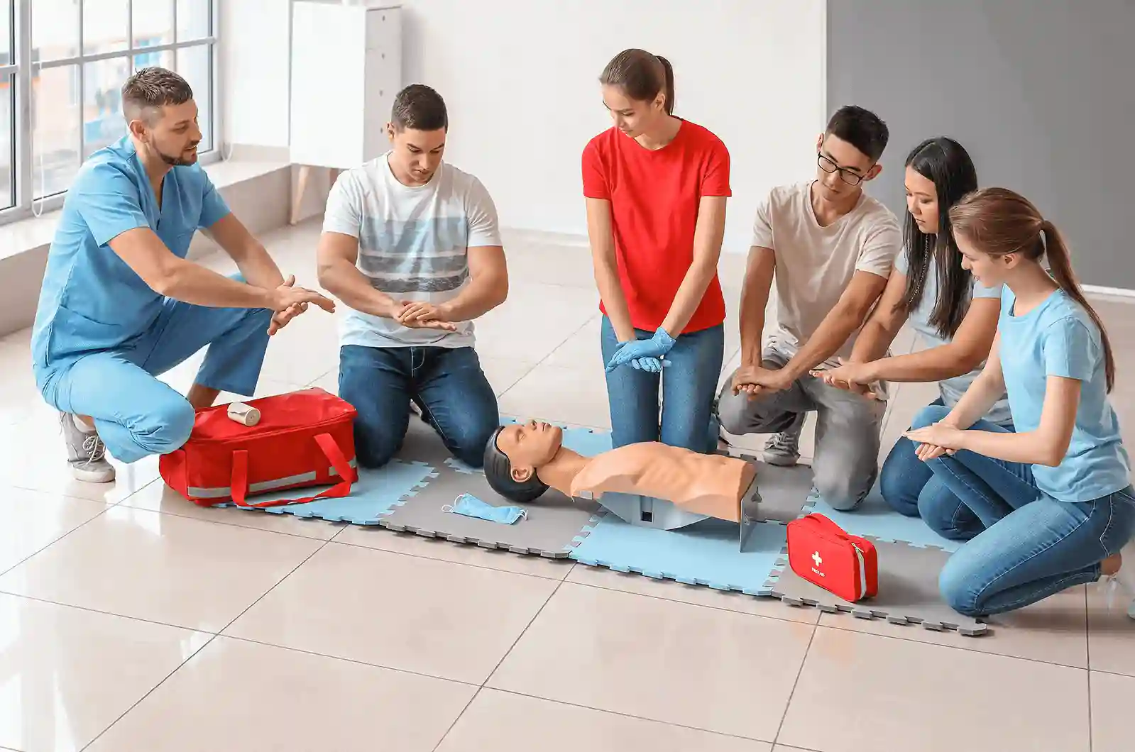 First aid class practising CPR on a training manikin